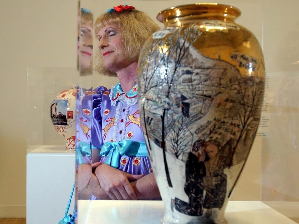 Künstler Grayson Perry posiert neben einer Vase.