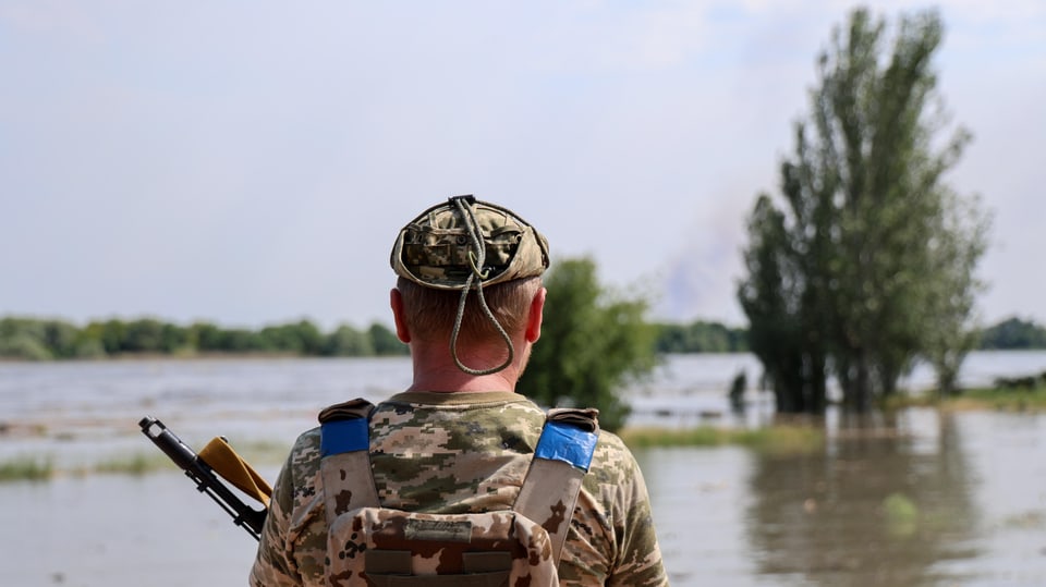 Ukrainischer Soldat blickt auf überflutete Strasse in Cherson