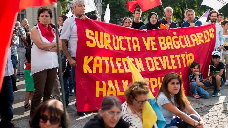 Kurden demonstrieren in Zürich mit Fahnen und Transparenten.