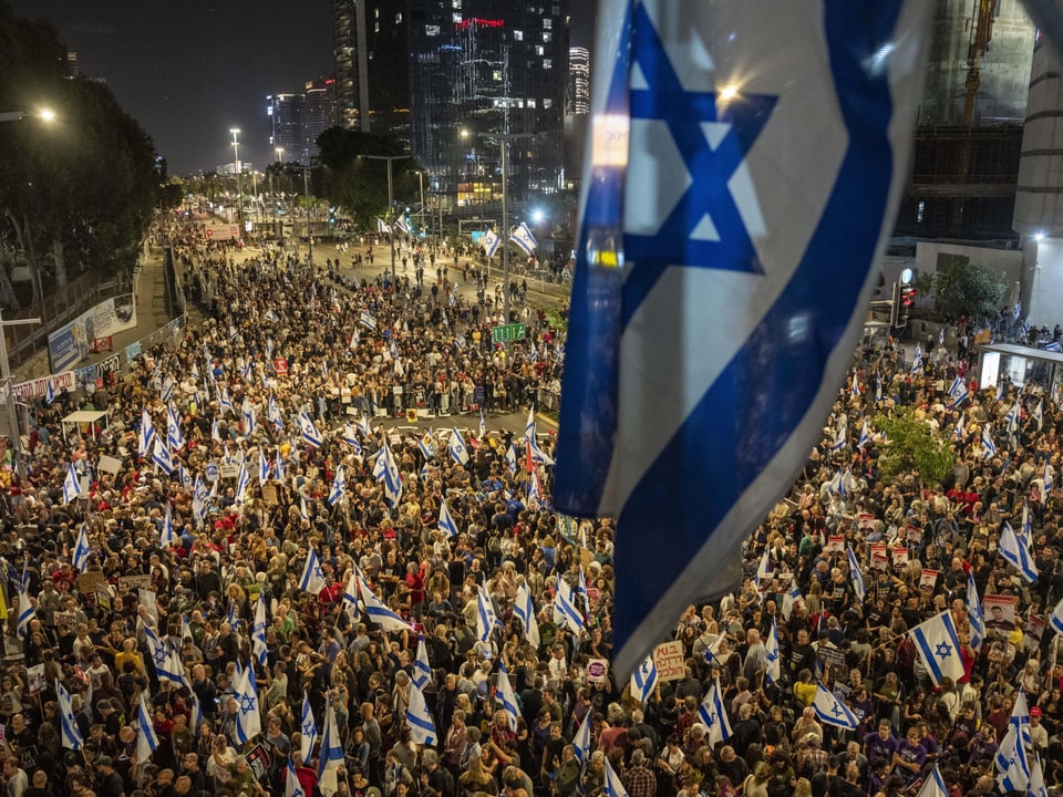 Grosse Menschenmenge bei einer Demonstration in der Stadt mit israelischen Flaggen.