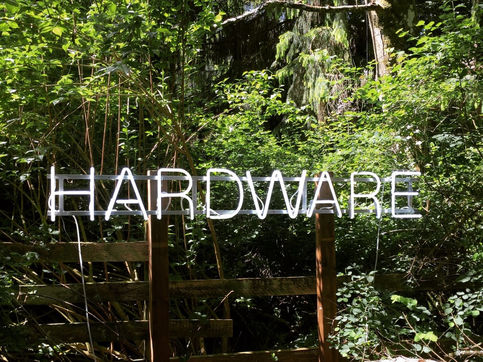 Leuchtschrift "Hardware" im Wald