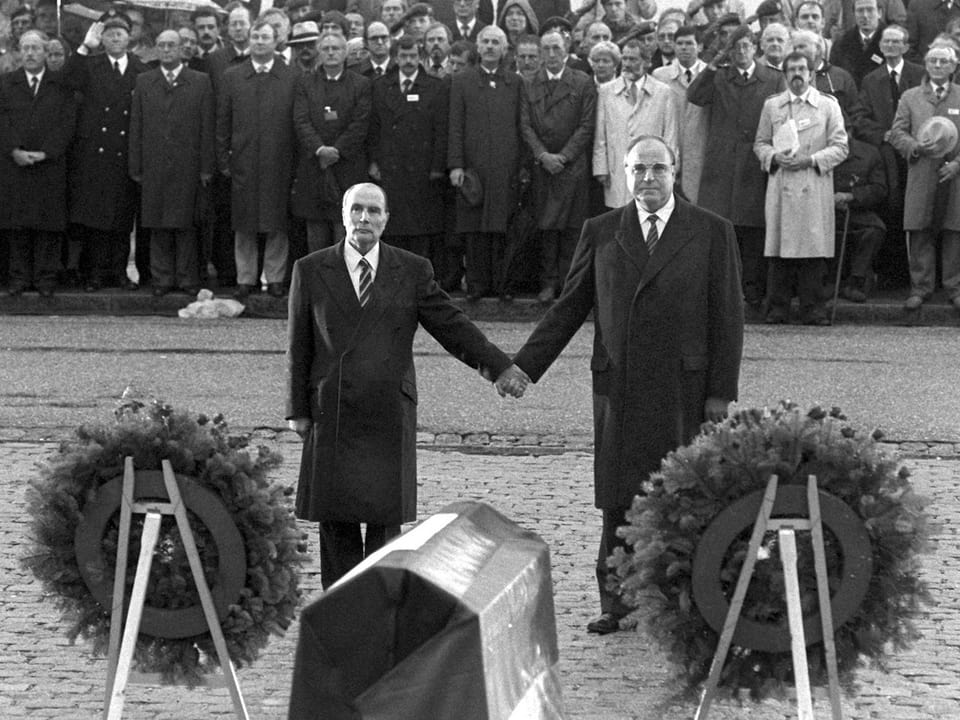 François Mitterrand (l) und Helmut Kohl, sich an den Händen haltend.