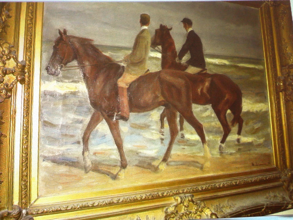 Ein Gemälde mit zwei Reitern drauf, die am Strand sind.