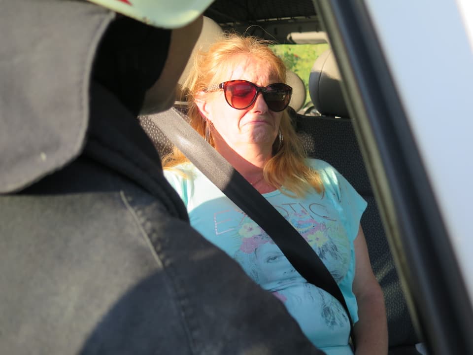 Figurantin Vera Leuenberger sitzt im Auto und schaut traurig