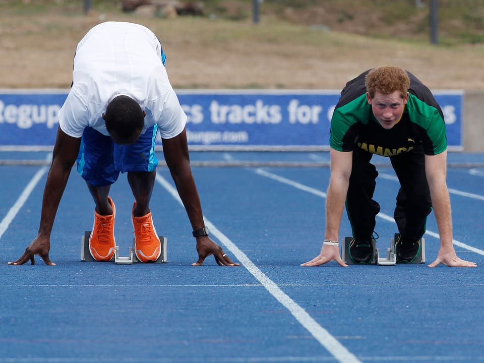 Prinz Harry und Usain Bolt warten beim Sprint auf den Startschuss.