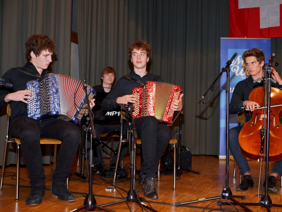 Zwei junge Akkordeonspieler, ein Pianist und ein Cellist während des Auftritts.