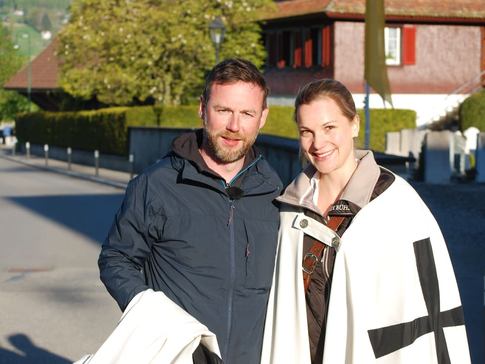 Nik Hartmann posiert mit junger Frau in weissem Umhang. 