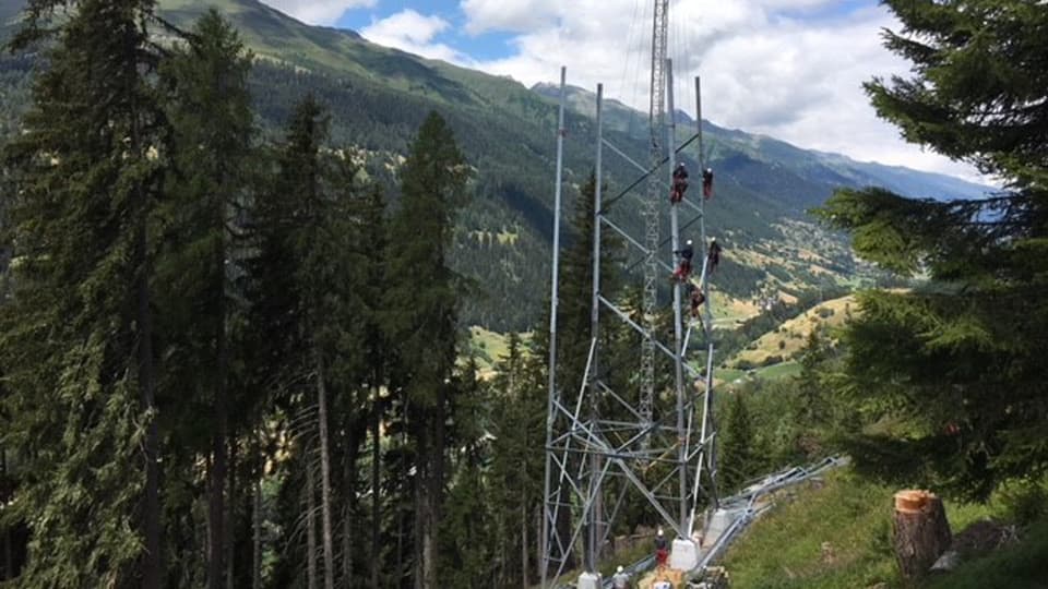 Bauarbeiter arbeiten an einem Strommast.