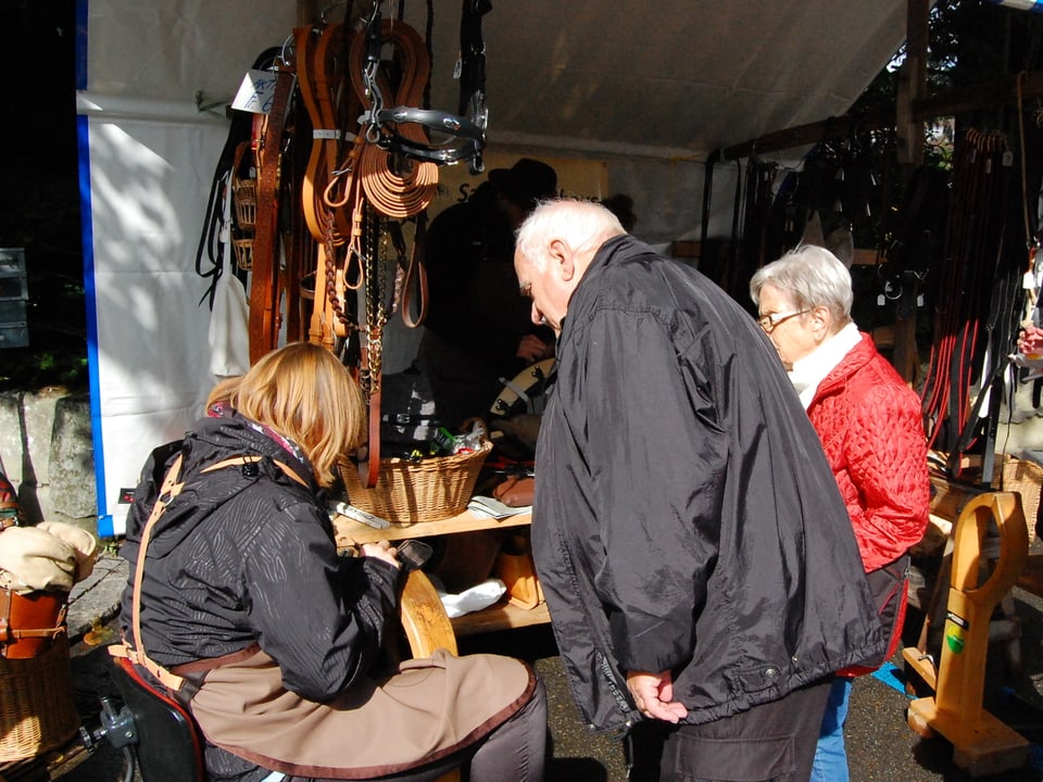 Publikum schaut auf dem Markt dem Sattlerhandwerk zu.