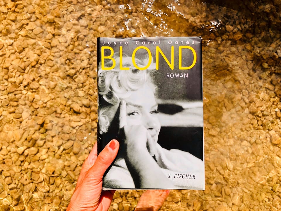 Annette König hält den Roman «Blond» von Joyce Carol Oates vors Wasser
