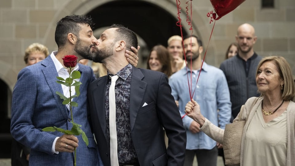Zwei Männer küssen sich vor dem Zürcher Standesamt. Sie ihre eingetragene Partnerschaft in eine Ehe umgewandelt haben.