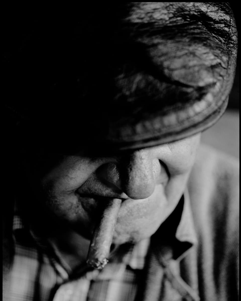 Ein alter Mann mit Zigarillo im Mund.