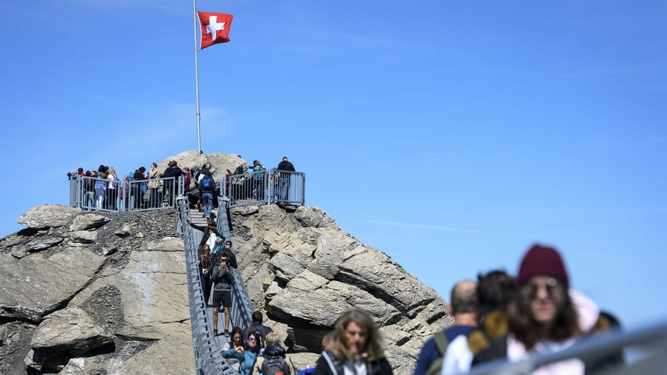 Touristen gehen über die Hängebrücke im Diablerets-Massiv der Berner Alpen.