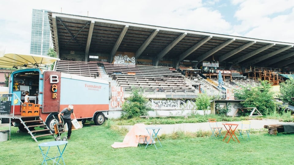 Die Tribüne des Stadions Gurzelen im Hintergrund und im Vordergrund ein Gemüsebeet. 
