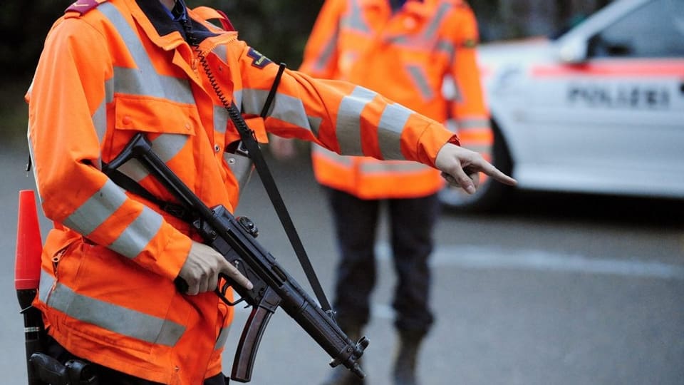 Polizisten der Zürcher Kantonspolizei (ohne Kopf) bei einer Kontrolle mit Maschinenpistolen.