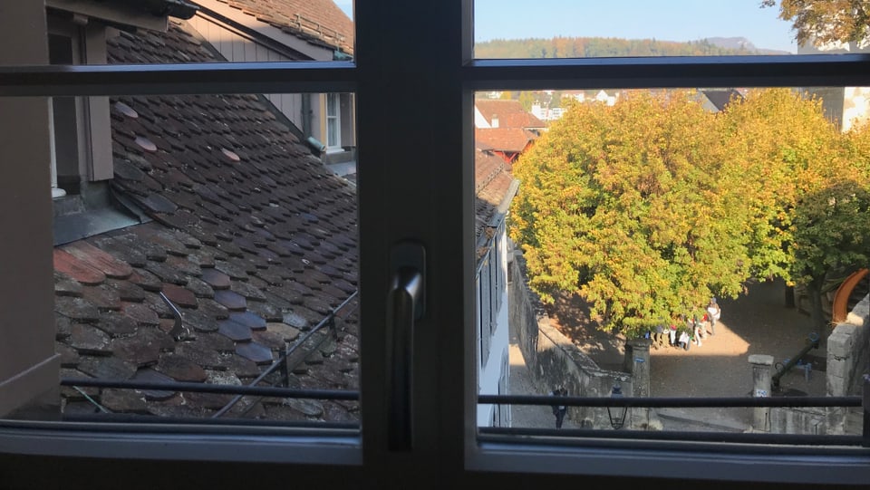 Blick aus einem Fenster auf die Dächer einer Altstadt.