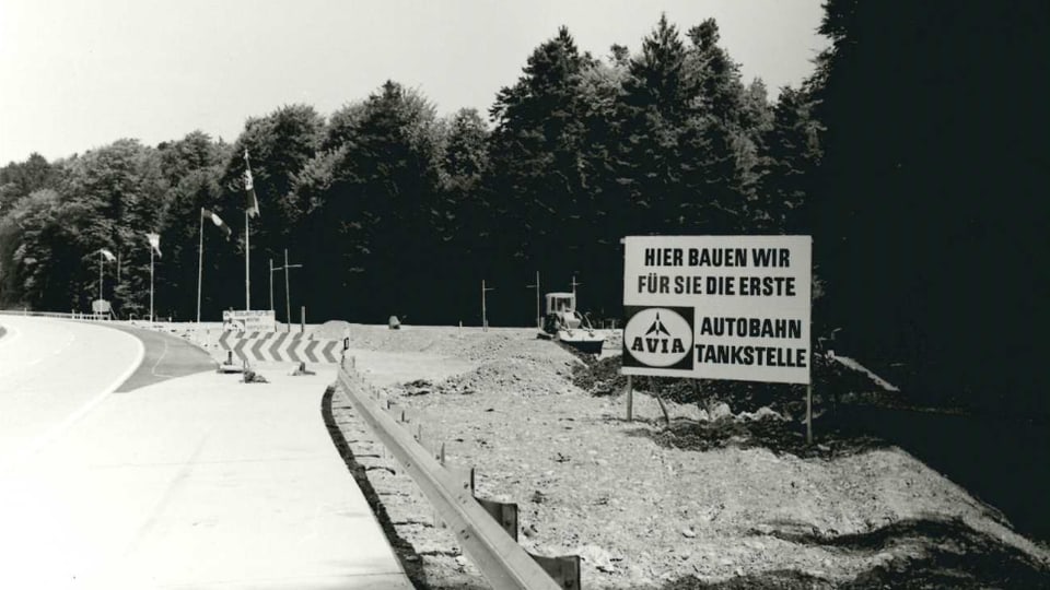 Schild an Autobahn: "hier bauen wir für Sie die erste Autobahntankstelle der Schweiz"