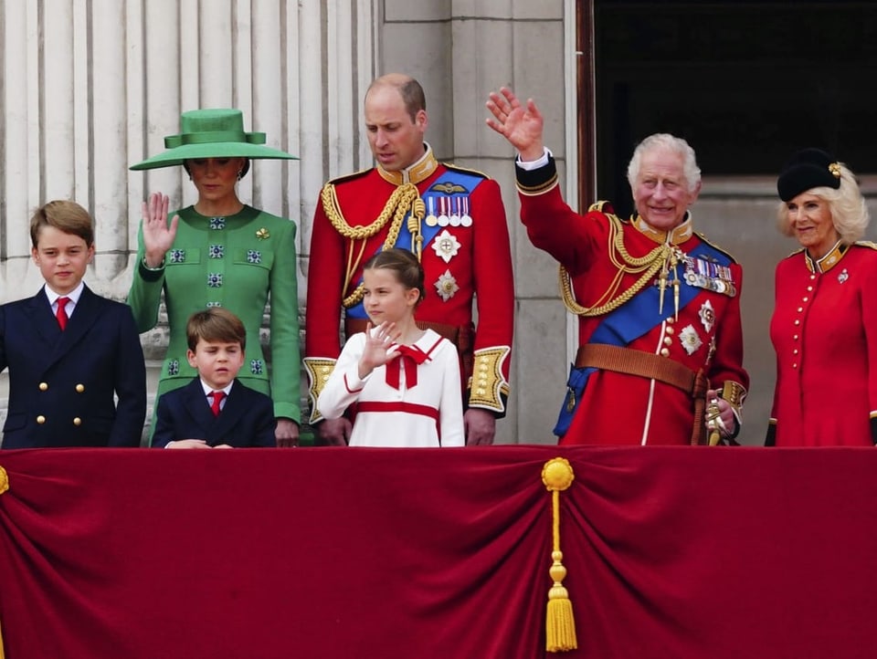 Die Royal Family winkt vom Balkon aus.