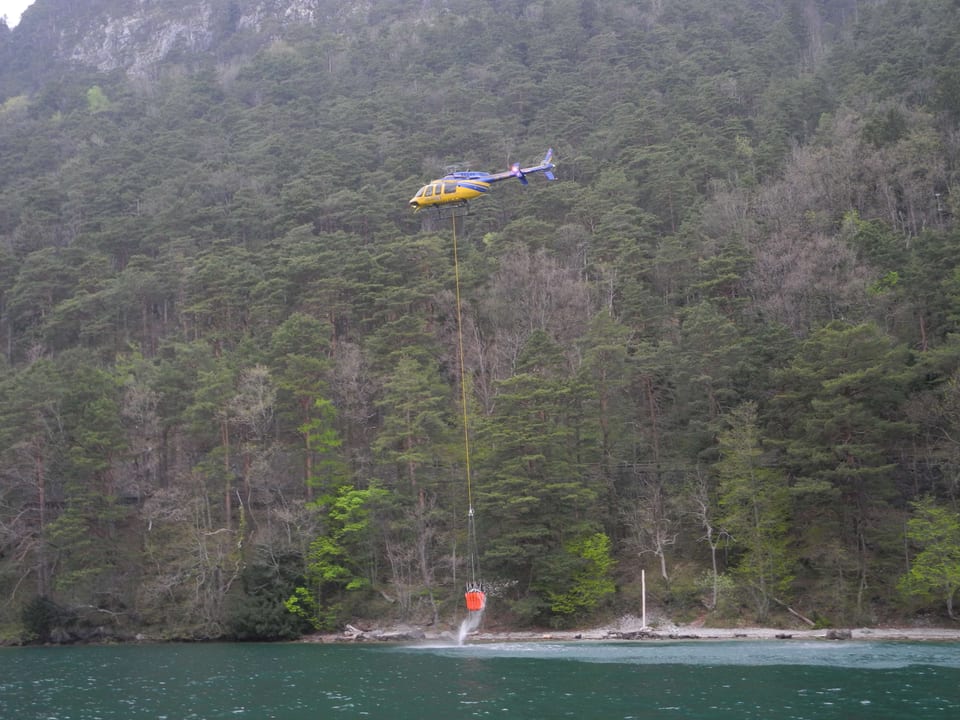 Ein Helikopter holt Löschwasser aus dem Vierwaldstättersee.