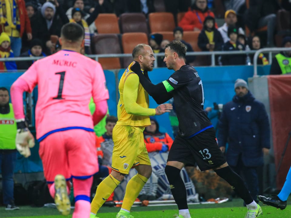 Jogadores de futebol discutem em campo.