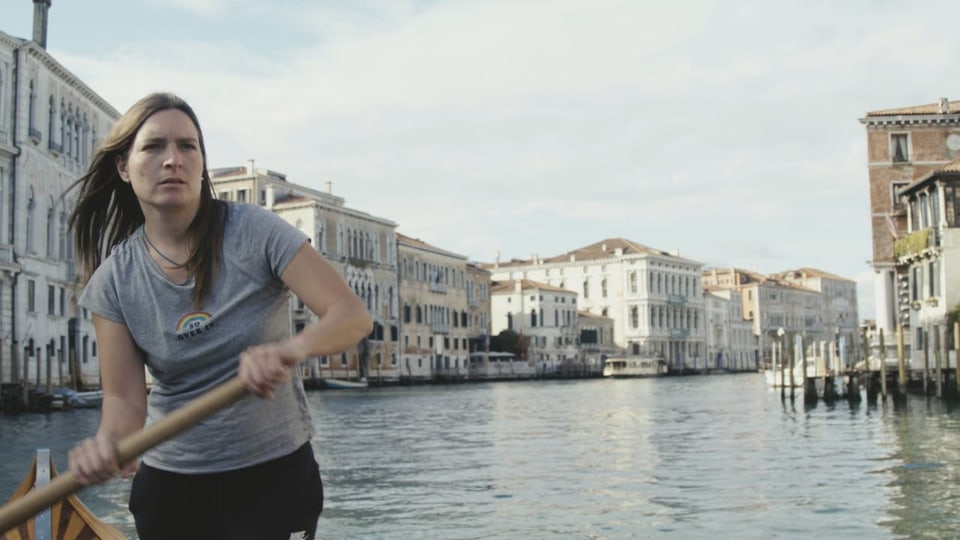 eine Frau hält ein Runder und schippert übers Wasser