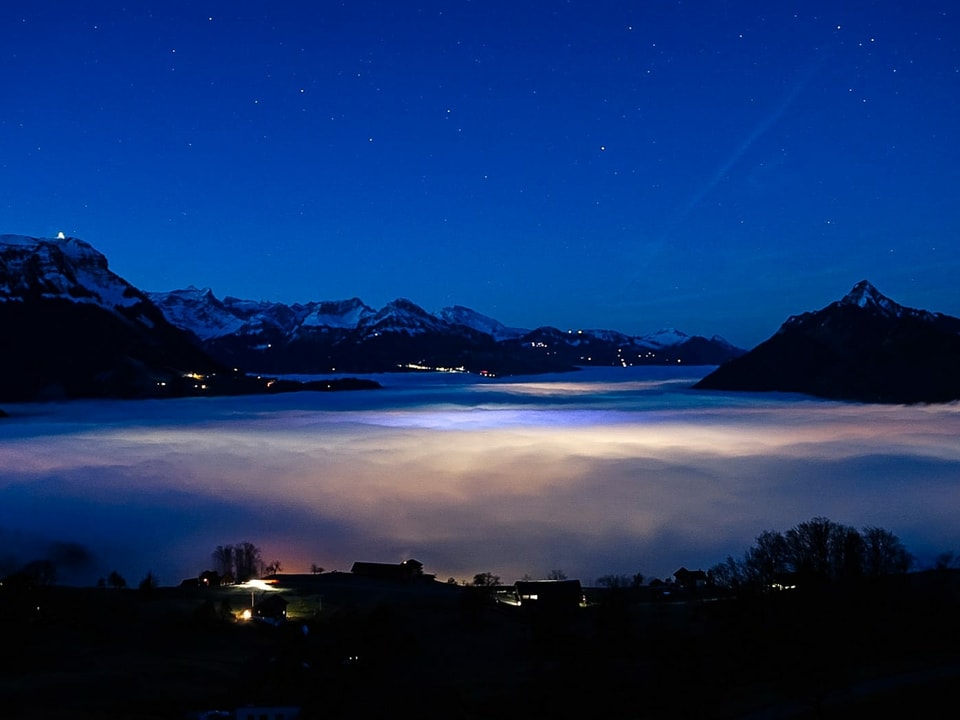 Blick auf eine Nebelmeer mit Lichtermeer.