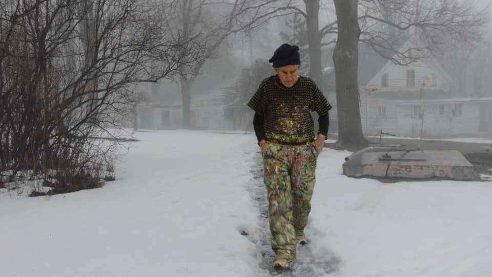 Larry Poons hat Farben auf seinem Gewand. Er stapft durch den Schnee.