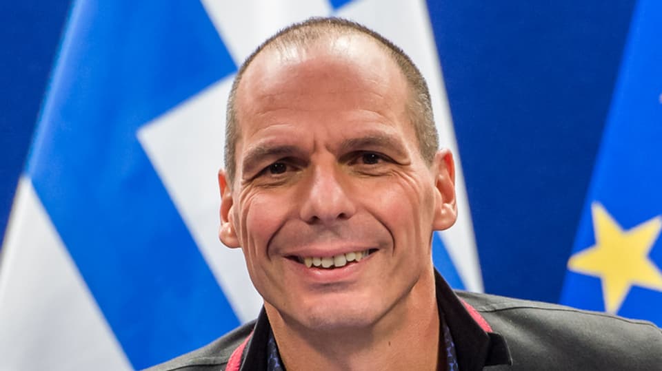 Varoufakis vor der europäischen und griechischen Fahne.