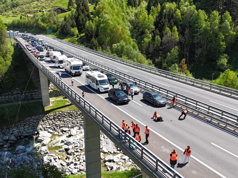Luftaufnahme einer Autobahnbrücke mit Verkehrsstau und Einsatzkräften bei einem Unfall.