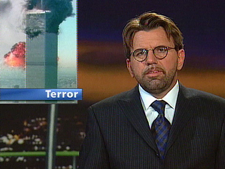 Porträt von Stephan Klapproth im «10vor10»-Studio, mit Einblendung der brennenden Twin Towers.