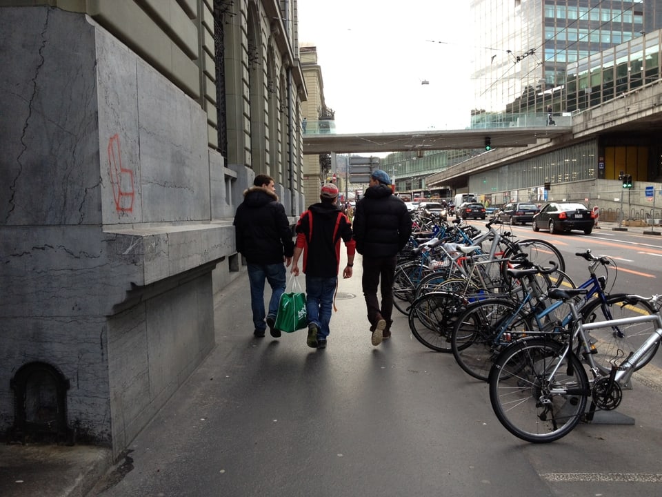 Drei Jugendliche von hinten auf dem Weg zum Bahnhof Bern.