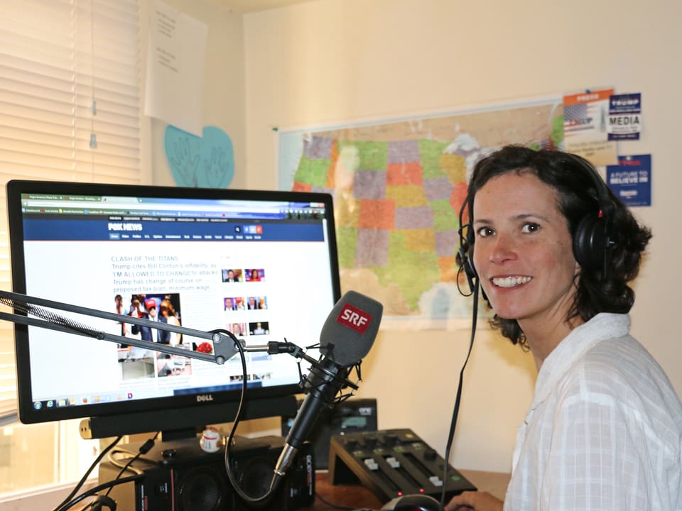Korrespondentin in ihrem Büro mit Mikrofon und Bildschirm.