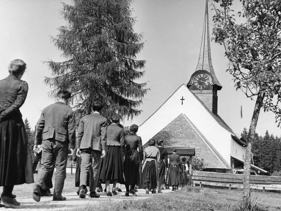 Kirchgänger pilgern zur kleinen Kirche im Hintergrund.