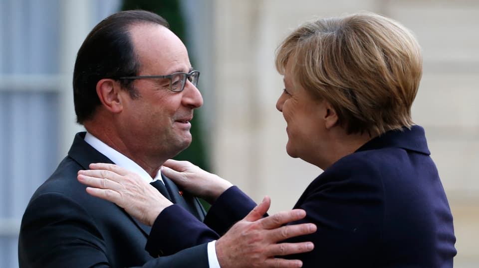 François Hollande und Angela Merkel geben sich eine Umarmung