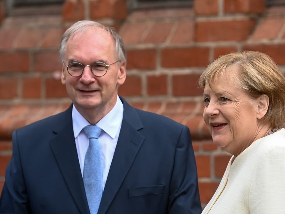 Reiner Haseloff und Angela Merkel stehen nebeneinander.
