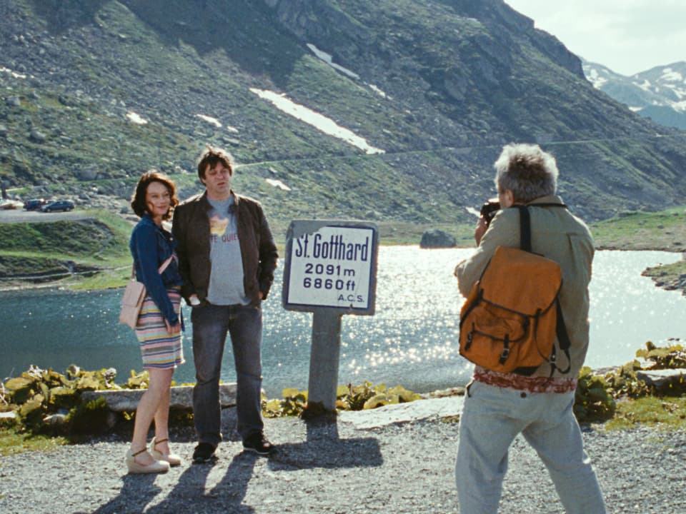 Ein Mann macht ein Foto von einem Paar auf dem Gotthard-Pass.