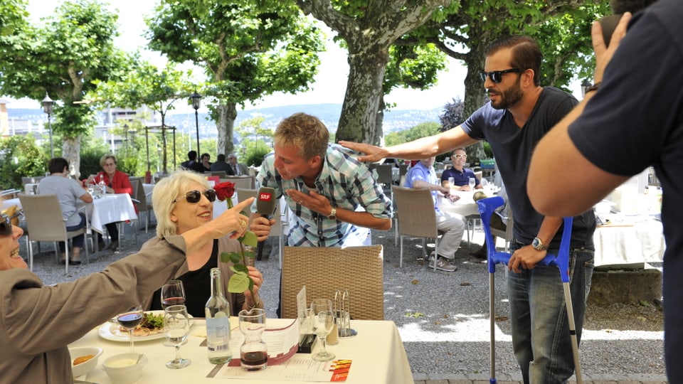 Reto und Bligg schenken einer Restaurant-Besucherin eine Rose