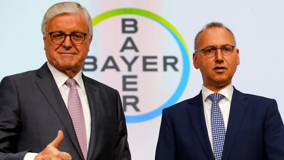 Werner Wenning und Werner Baumann vor Bayer-Logo.