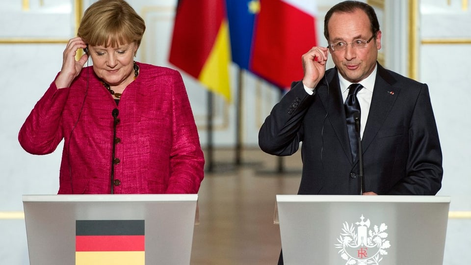 Die deutsche Bundeskanzlerin Angela Merkel (links) und Frankreichs Präsident François Hollande (rechts) hinter Rednerpulten
