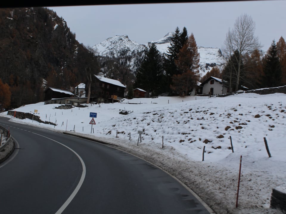 Eine Strasse, im Hintergrund verschneite Landschaft.