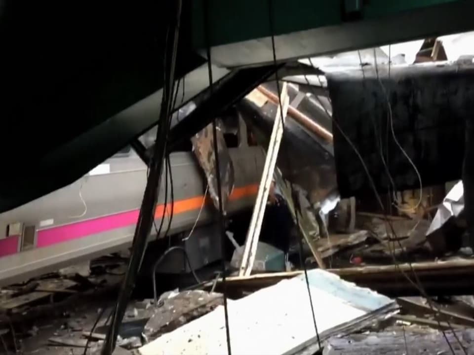 Teilweise zerstörter Zug und eingestürzte Dachteile