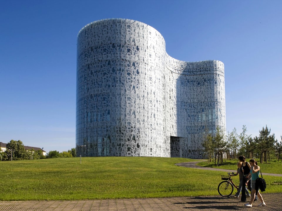 Die Bibliothek von aussen zeigt eine stromlinienförmige Fassade mit verschiedenen Strukturen.