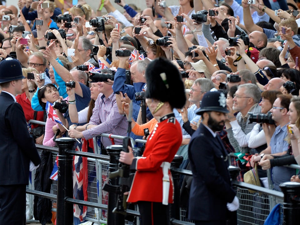 Viele Menschen stehen an einer Absperrung in London, um die britischen Royals zu bestaunen.