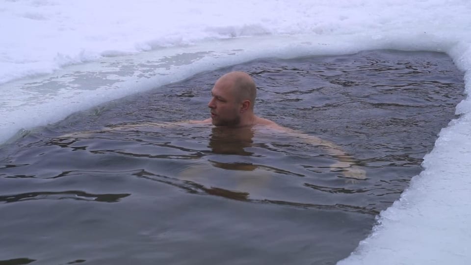 Ein Mann badet in Eiswasser.