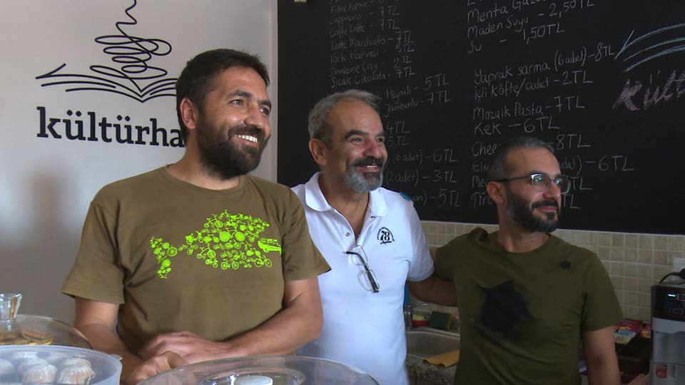 Drei lächelnde Männer in einem türkischen Café
