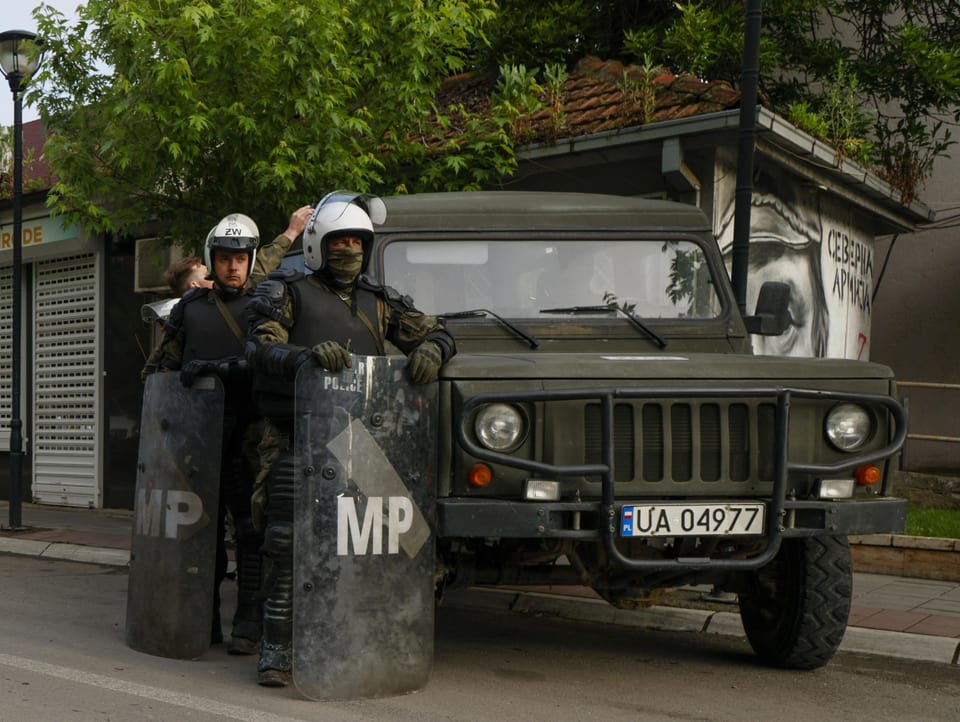 Soldaten in Demonstrationsmontur stehen neben einem Militärgeländewagen.
