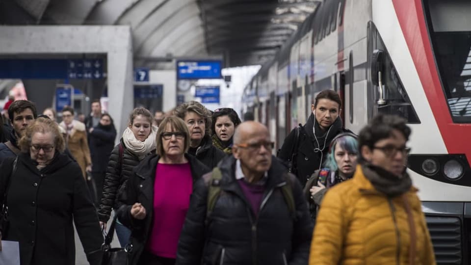 Pendler bewegen sich über ein Perron am Bahnhof Zürich. 