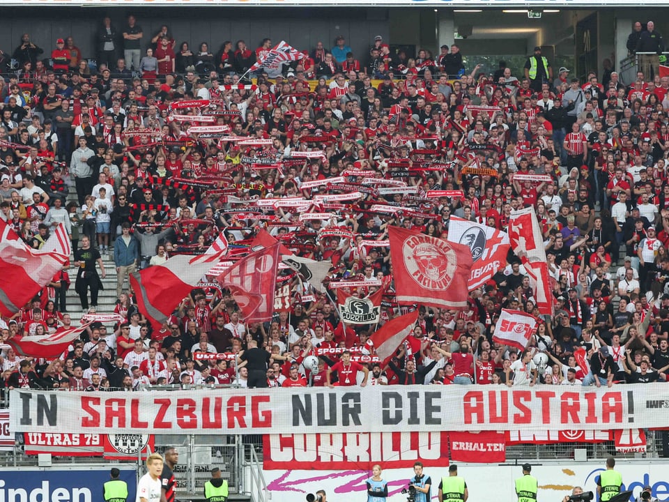 Ein Plakat mit «In Salzburg nur die Austria» wird in die Höhe gehalten.