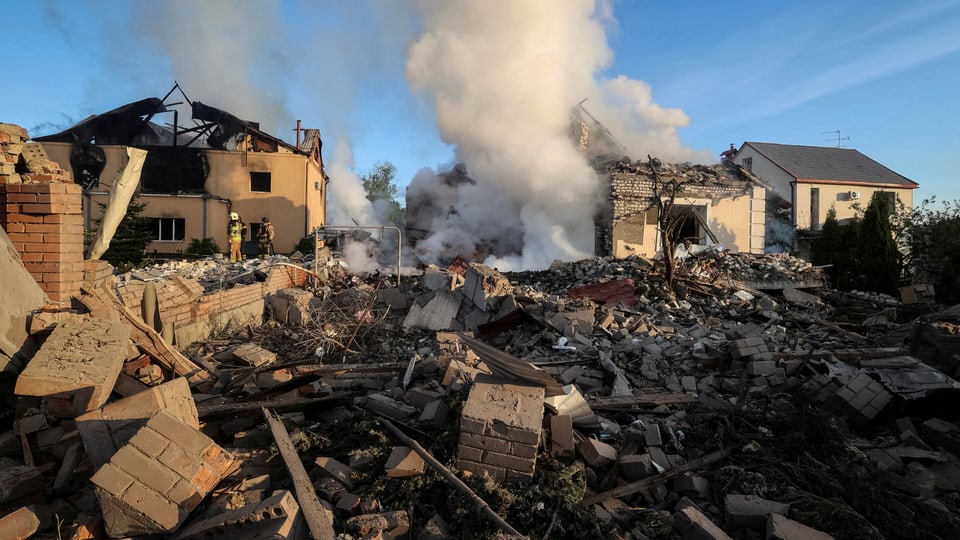 Zerstörte Häuser mit Trümmern und Rauch nach einer Explosion