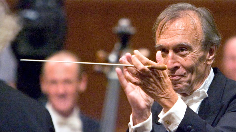 Abbado applaudiert mit Dirigentenstab in der Hand einem Musiker
